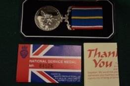 A National Service medal, boxed.