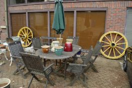 Hardwood extending garden table with six folding armchairs and a parasol.