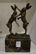 A small bronze group of fighting hares on a marble base.