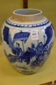 A large Chinese blue and white jar decorated with figures in a landscape.