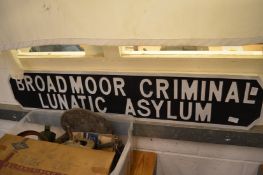 A carved wood and painted novelty sign 'Broadmoor Criminal Lunatic Asylum'.