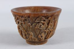 A CHINESE CARVED HORN BOWL with figures and foliage. 3ins high x 4.5ins diameter.