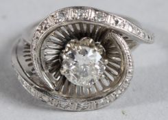 A DIAMOND ART DECO SWIRL RING with 1.2ct centre stone.
