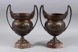 A GOOD PAIR OF 19TH CENTURY BRONZE TWO HANDLED URN SHAPED VASES on circular marble bases. 11ins