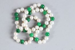 A STRING OF JADE BEADS AND PEARLS with a gold clasp.