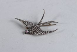 A DIAMOND SWALLOW BROOCH, set with a ruby eye.