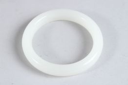 A CHINESE WHITE JADE CARVED BANGLE. 3.5ins diameter.
