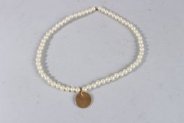 A PEARL NECKLACE with a gilt coin.