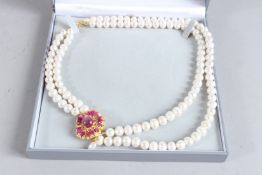A SILVER AND GOLD PLATED RUBY SET TWO ROW PEARL NECKLACE.