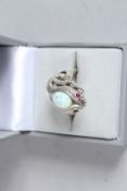 A SILVER OPAL AND RUBY EYE SNAKE RING.