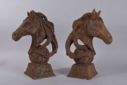 A PAIR OF CAST IRON HORSES HEADS. 14ins high.