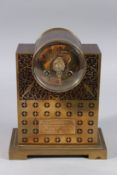 A GOOD BRASS INLAID MANTLE CLOCK inlaid with birds and motifs, and circular dial. 8ins high.