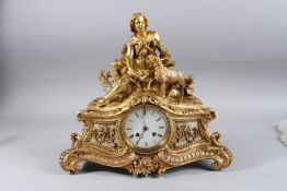 A FRENCH GILT METAL CLOCK surmounted by a shepherd girl and sheep. 15ins high.