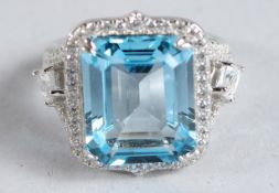 A SILVER, BLUE TOPAZ AND CZ RING.