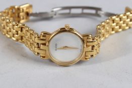 A LADIES' GUCCI GILT WRISTWATCH with mother-of-pearl face.
