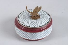A CIRCULAR PORCELAIN BOX AND COVER with metal dragonfly handle. 5ins diameter.