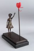 AFTER BANKSY. A BRONZE GIRL WITH RED HEART. Signed, on a marble base. 15ins high..