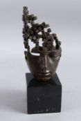 AN ABSTRACT BRONZE HEAD on a marble base. 12ins high.
