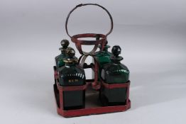 A GEORGE III FOUR BOTTLE GREEN DECANTER SET fitted with four green glass bottles and stoppers. Three