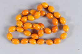 A STRING OF THIRTY-SIX AMBER BEADS.