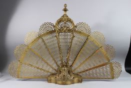 A FRENCH FOLDING GILT METAL FAN SHAPED FIRE SCREEN. 36ins open.