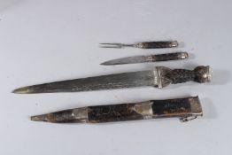 A GOOD SCOTTISH DIRK WITH KNIFE AND FORK, carved wooden handle and leather sheath, with