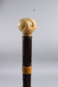 A WALKING CANE with carved HAND bone handle. 34ins long.