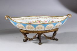 A SEVRES PORCELAIN BOAT SHAPED BON BON DISH on an ornate base with swags and claw feet. 11ins long.
