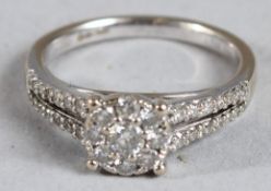 AN 18CT GOLD CLUSTER RING with diamond shoulders.