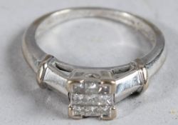 AN 18CT PRINCESS CUT DIAMOND CLUSTER RING.