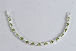 A SILVER AND PERIDOT TENNIS BRACELET.