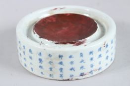 A CHINESE BLUE AND WHITE CIRCULAR INKSTONE, the sides with calligraphy. 5.5ins.
