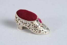 A SILVER RUBY SET SHOE PIN CUSHION.