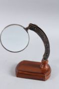 A MAGNIFYING GLASS on a stand.