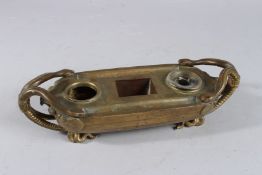 A GRAND TOUR BRONZE BODY SHAPED INKWELL with serpentine mounts. 11ins long.