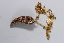 A CHANNEL TOOTH SHAPED PENDANT on a long chain.