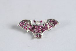 A SILVER AND RUBY SET BAT BROOCH/PENDANT with diamond eyes.