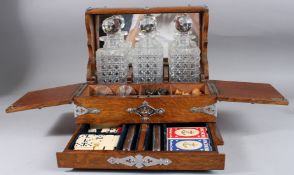 A GOOD EDWARDIAN THREE BOTTLE WHISKY TANTALUS AND GAMES COMPENDIUM, fitted with three whisky