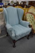 A GOOD GEORGIAN DESIGN WING ARMCHAIR with classical pale blue upholstery, supported on carved