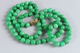 A GOOD STRING OF LARGE JADE BEADS with 14ct gold clasp. 42ins long.