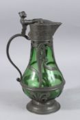 AN ART NOUVEAU GREEN TINTED GLASS AND PEWTER JUG. 12ins high.