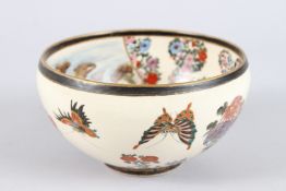 A JAPANESE SATSUMA BOWL, decorated to the centre with buildings on a mountainous river landscape,