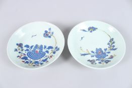 A PAIR OF CHINESE QUIANLONG PORCELAIN DISHES, each painted with a floral design. 20cms diameter.