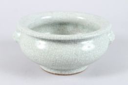 A CHINESE PORCELAIN CRACKLE GLAZE CIRCULAR CENSER, with mask handles. 22cms diameter.