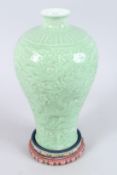 A FINE CHINESE CELADON MEIPING CARVED WITH DRAGONS. 12ins high, on a wooden stand.
