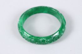 A CHINESE APPLE GREEN CARVED JADE BANGLE. 2.75ins diameter.