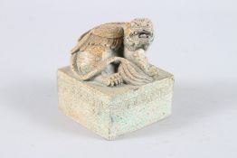 A CARVED HARDSTONE SQUARE SEAL, carved with a lion dog. 9.5cms wide.