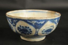 AN EARLY PERSIAN BLUE AND WHITE GLAZED POTTERY BOWL, painted with floral motifs, provenance: