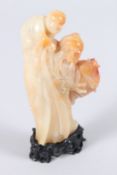 A GOOD CHINESE CARVED TWO COLOUR JADE MAN AND YOUNG BOY. 4.25ins high, on a wooden stand.