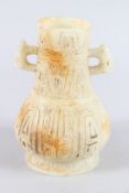 A CHINESE ARCHAIC FORM CARVED JADEITE TWIN HANDLED VASE. 21cms high.